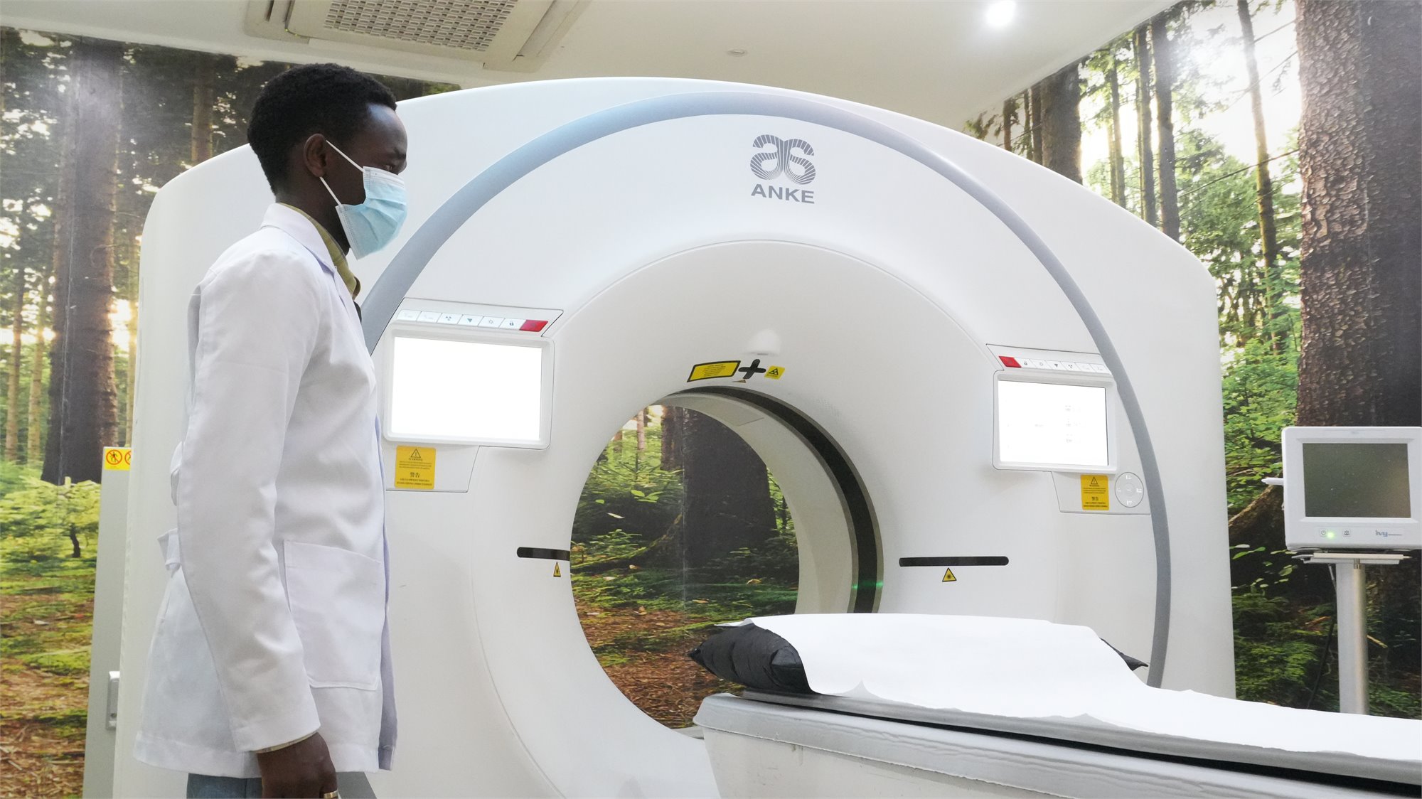 Rayhaan Healthcare technologist beside the CT scanner
